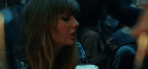 GIF de Taylor brindando em um bar cheio.